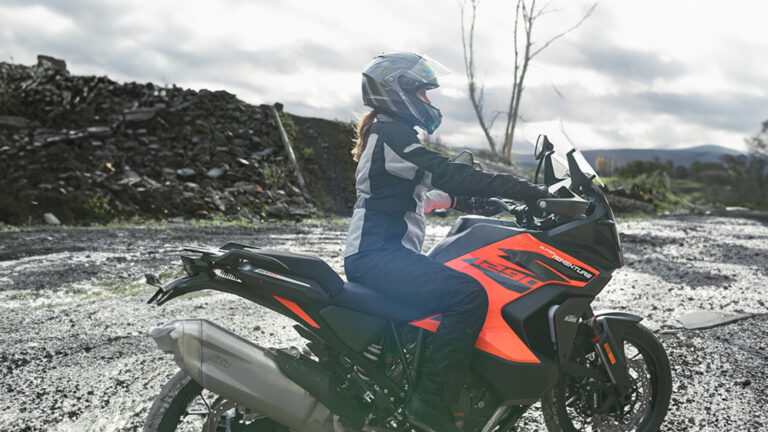 conductrice habillé d'équipement de protection sur moto orange